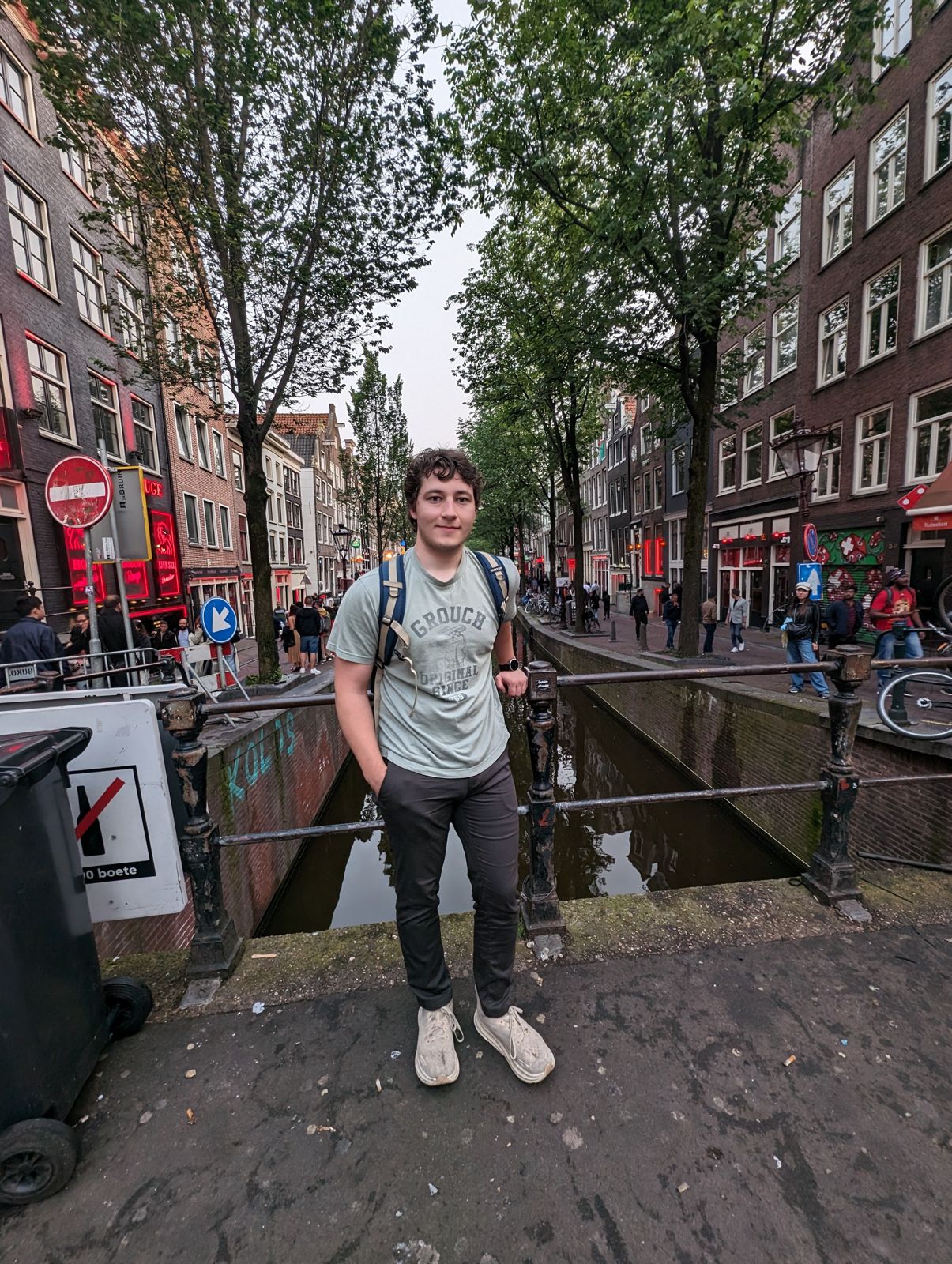 Standing by a canal on a tree-lined city street